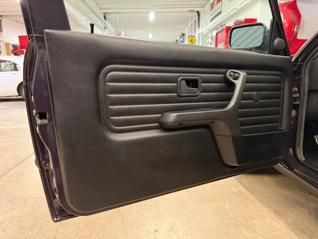 Türverkleidung eines BMW 325i E30 AC Schnitzer im klassischen Design, mit sichtbarem Türpanel bei geöffneter Tür
