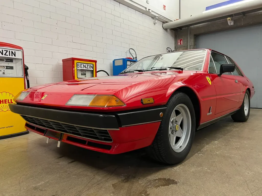 chräg von vorne auf der Fahrerseite eines Ferrari 400i Classic GT, mit Fokus auf Stoßstange, Scheinwerfer und Vorderrad im klassischen Design