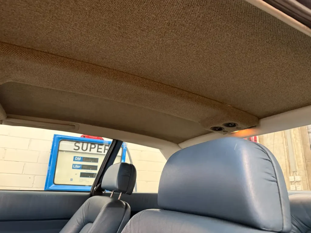 Sicht auf Kopfstuetze und Dachhimmel des Ferrari 400i in blau Handschalter V12 Oldtimers.