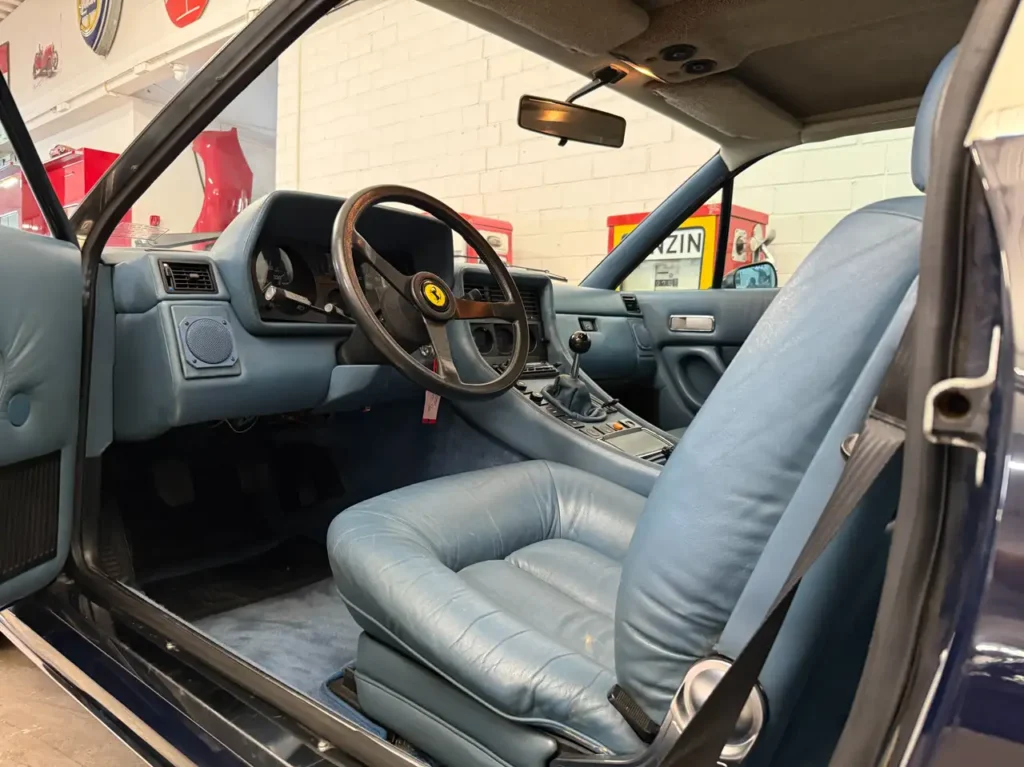 Fahrersitz und Lenkradansicht des Ferrari 400i in blau Handschalter V12 Oldtimers.