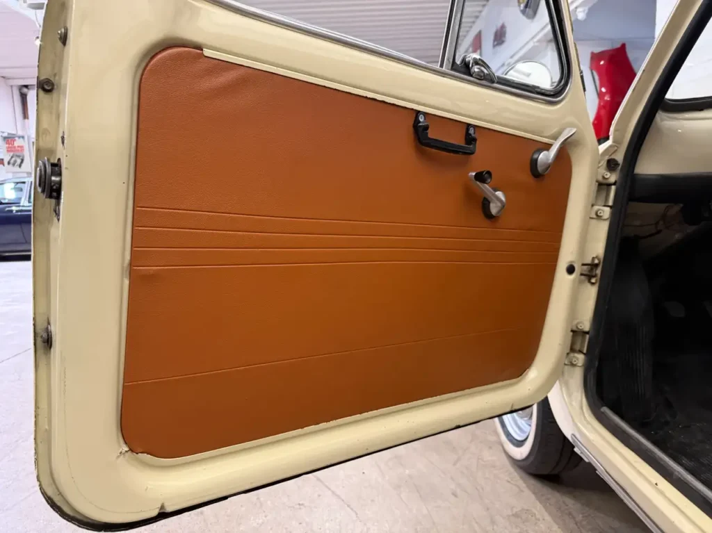 Geoeffnete Fahrertuer mit Seitenverkleidung und Fensterheber des Fiat 500L Oldtimers