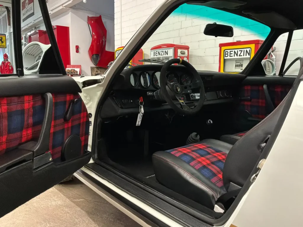 Porsche Carrera 1975 weisses Coupe Sicht durch geoeffnete Fahrertuer auf Innenraum.