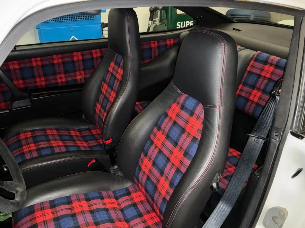 Porsche Carrera 1975 weisses Coupe Sicht auf den Innenraum karierte Sitze.