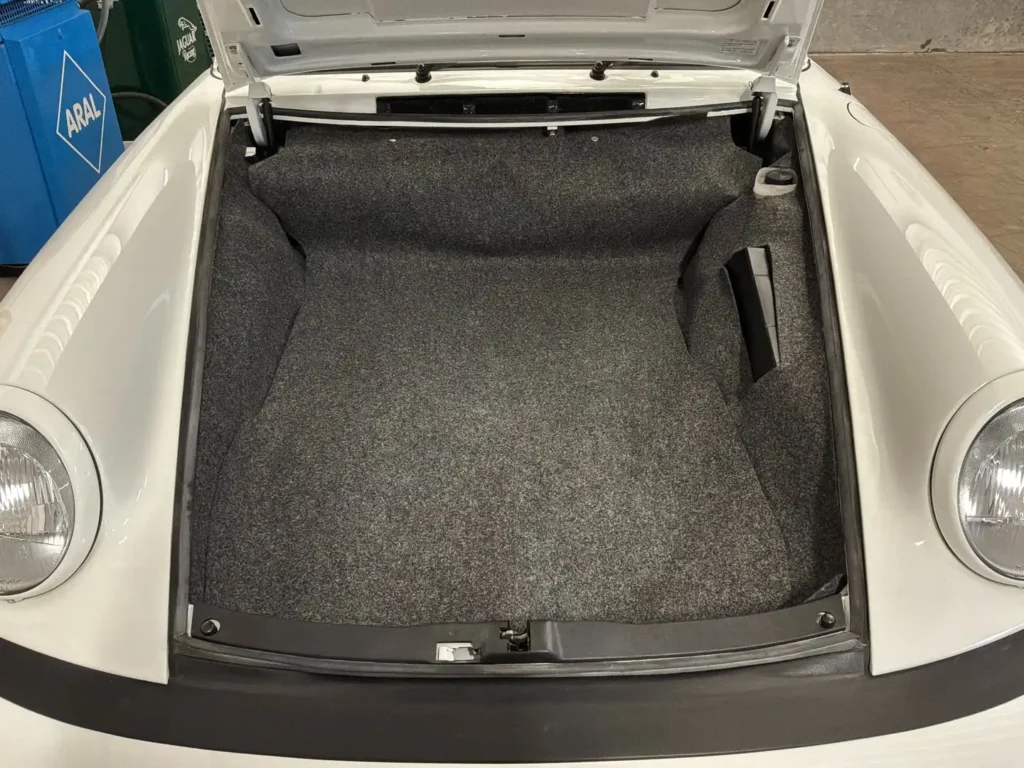 Porsche Carrera 1975 weisses Coupe Sicht auf den geoeffneten Kofferraum.