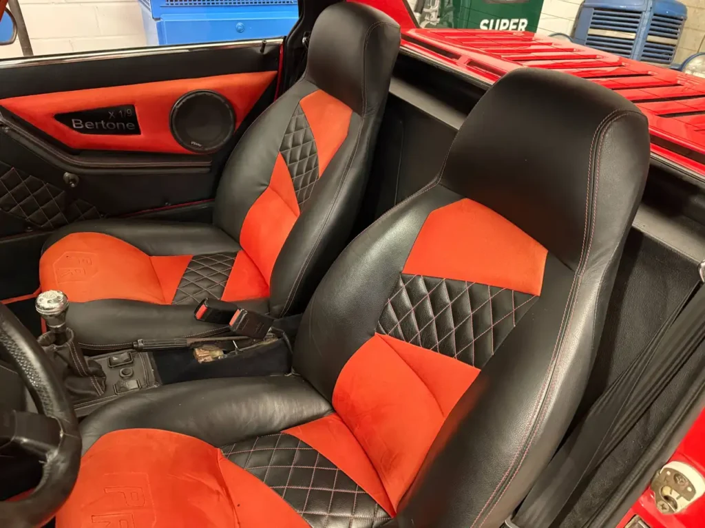 Fiat X1/9 Fahrersitz in rot schwarz.