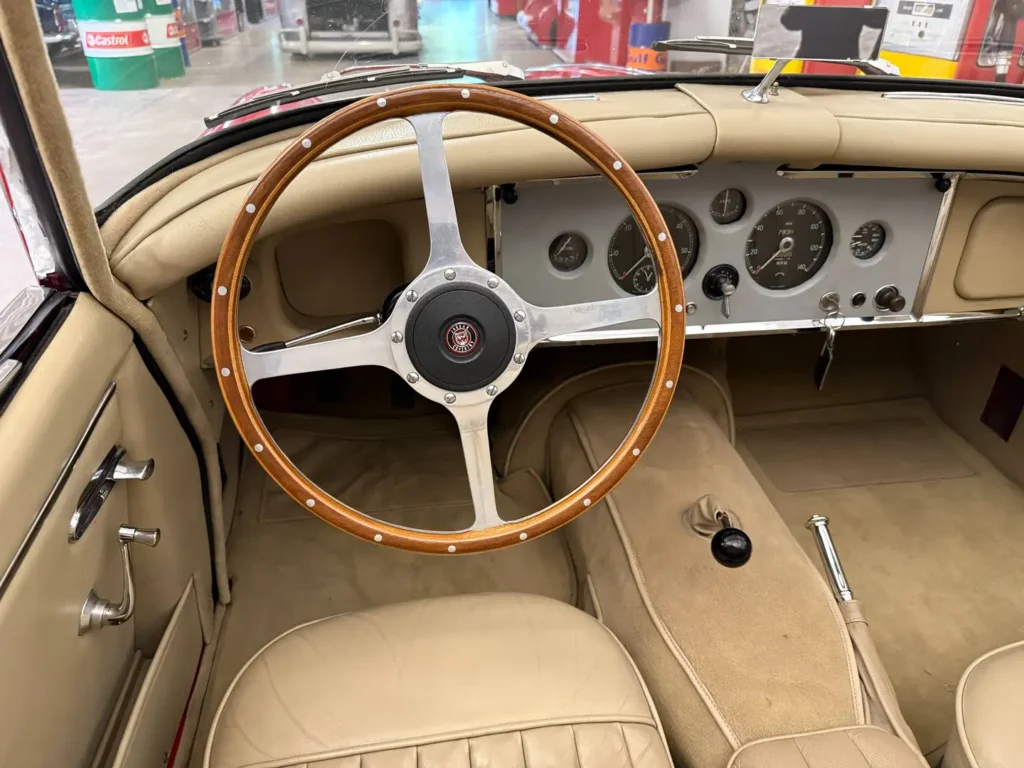 Jaguar XK150 1958 rot Sicht auf Lenkrad und Armaturen.