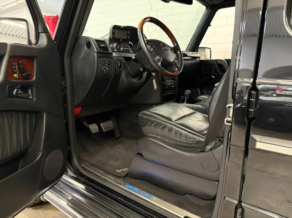 Mercedes Benz G55 AMG schwarz Foto von geoeffneter Fahrertuer.