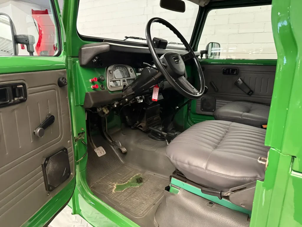 Toyota Landcruiser BJ42 1981 Bild von geoeffneter Fahrertuere und Lenkrad.