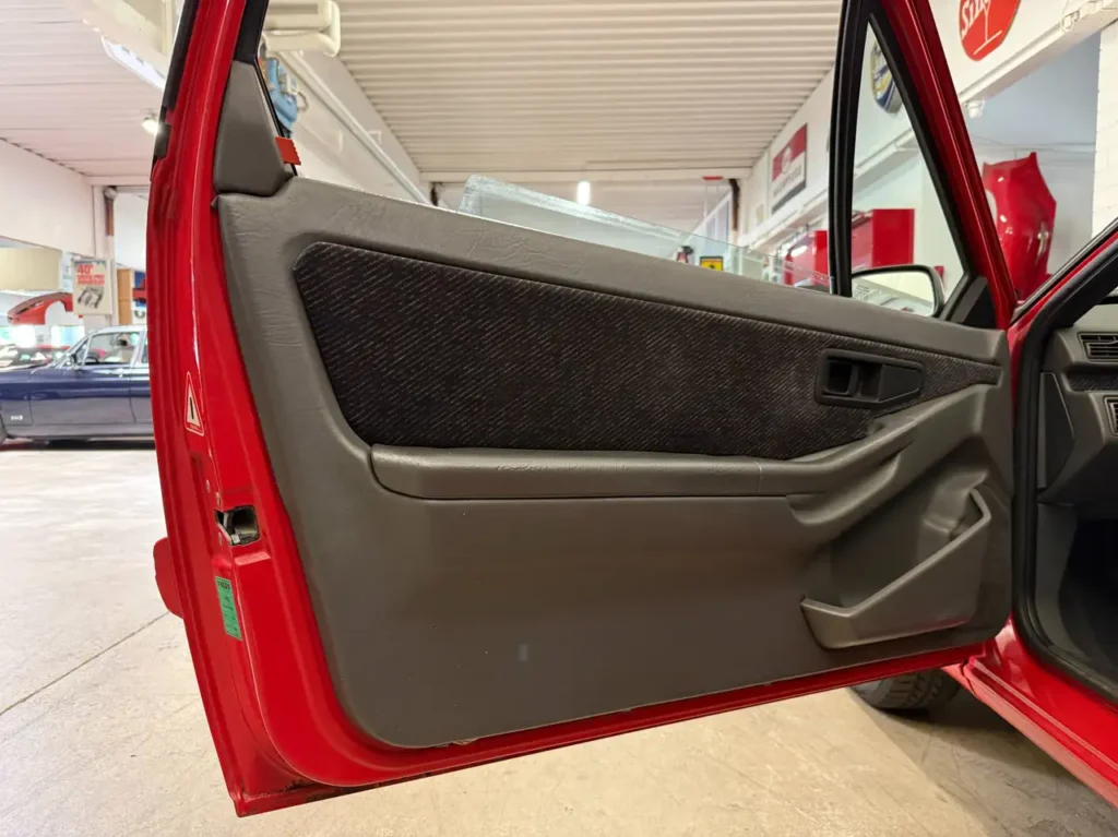Volvo 480 S 1994 in Rot Foto von der offenen Fahrertuer mit Seitenverkleidung.