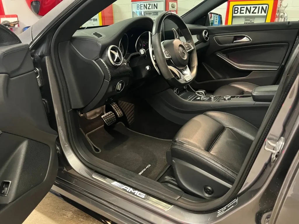 Mercedes Benz AMG CLA 45 Sicht auf offene Fahrertuer mit Lenkrad in schwarz.