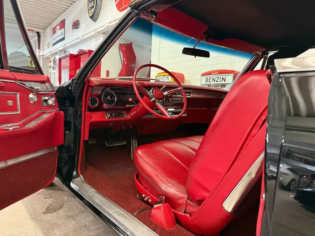 Cadillac DeVille Baujahr 1966 V8 Cabriolet schwarz, Fahrertuere offen sicht auf rotes Leder.