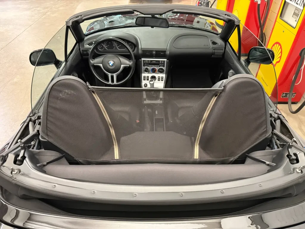 BMW Z3 Cabriolet Roadster 2001 in Schwarz, Lederlenkrad sicht auf Innenausstattung mit offeneme Verdeck.